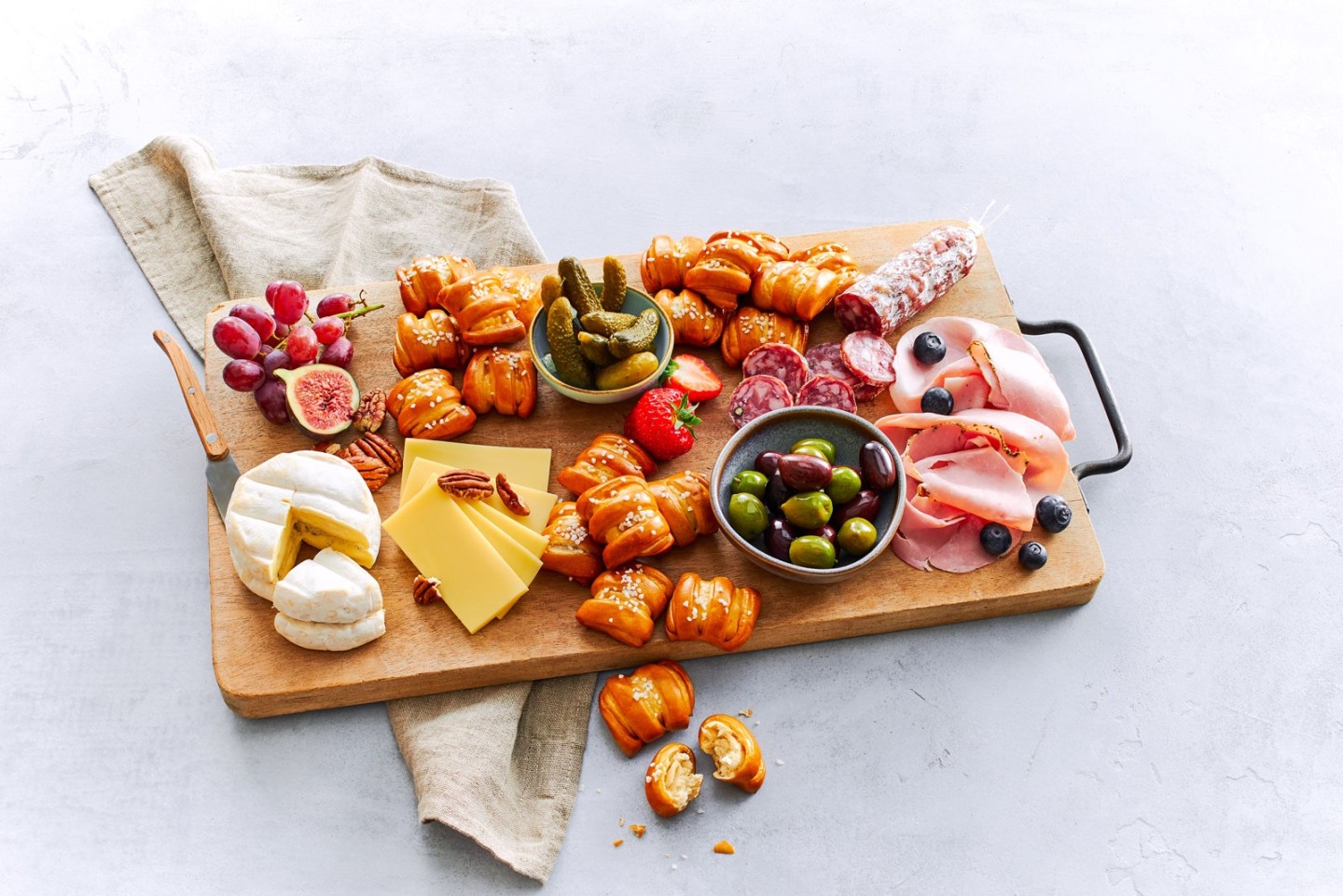 Ditsch Pretzel Bites auf Charcuterie-Brett mit Kaese, Salami, Oliven, Feigen, Weintrauben.