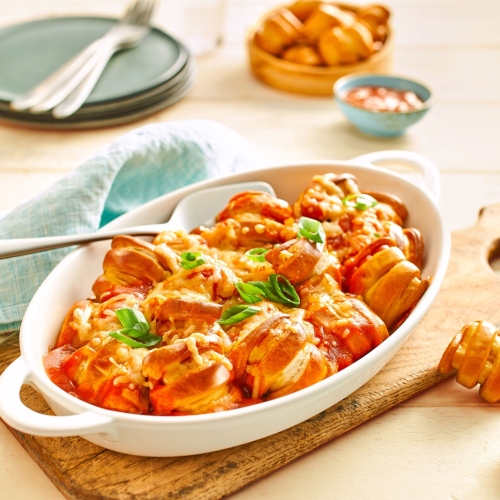 Pretzel Bites in Tomatensauce, mit Kaese ueberbacken und mit Fruehlingszwiebeln garniert.