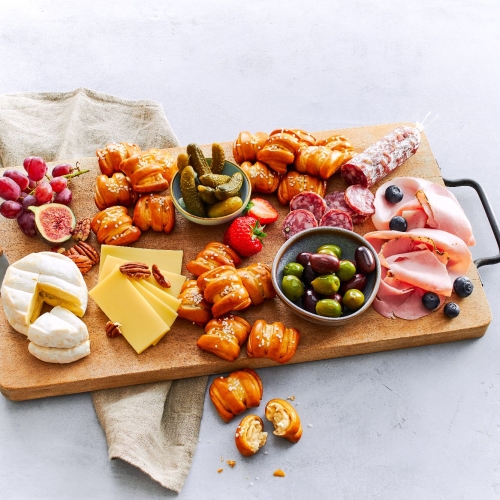 Ditsch Pretzel Bites auf Charcuterie-Brett mit Kaese, Salami, Oliven, Feigen, Weintrauben.