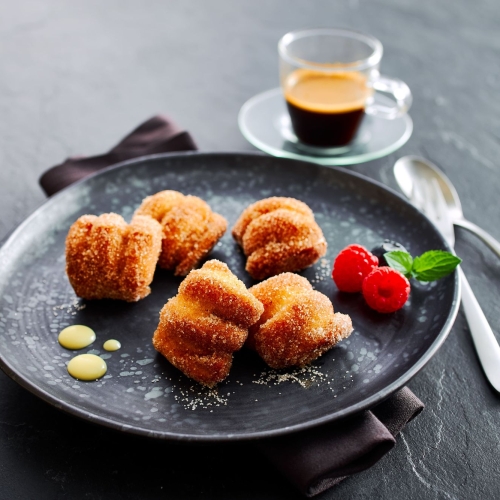 Ditsch Dessert Bites in Zucker gewaelzt, als Dessert mit Fruechten und Sossen angerichtet.