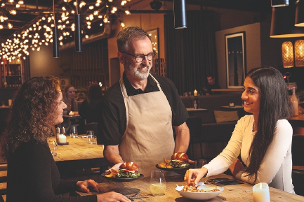 Service staff and guests in a dining setting with Ditsch pretzel products.