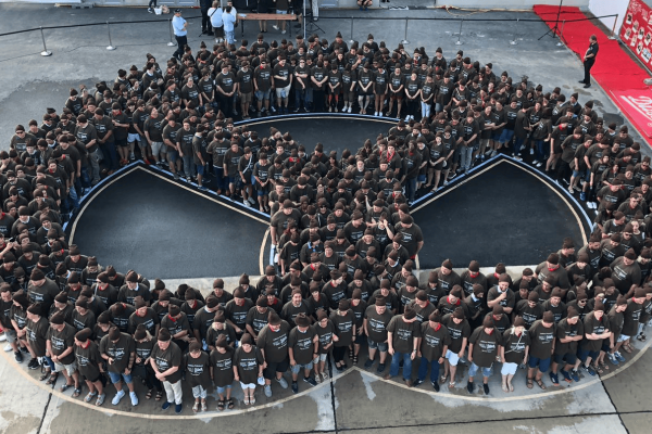Aerial view: Hundreds of Ditsch employees forming the Ditsch pretzel logo together.