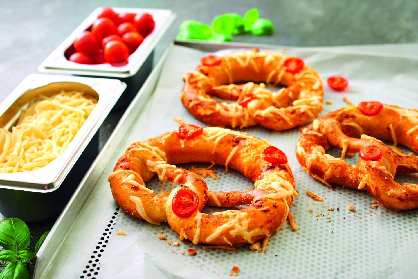 Two lye pretzels as pizza: tomato sauce, cheese and cherry tomatoes, baked.