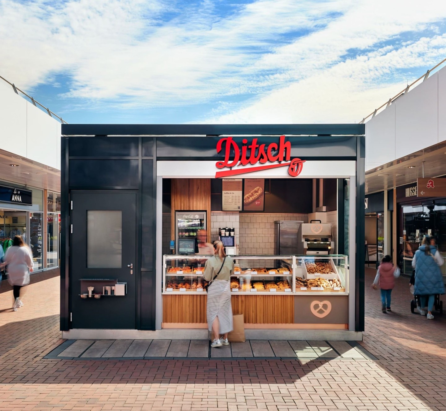 Kastenförmiger Ditsch Shop mit Bedientheke. Darum verschiedene Einkaufsläden.