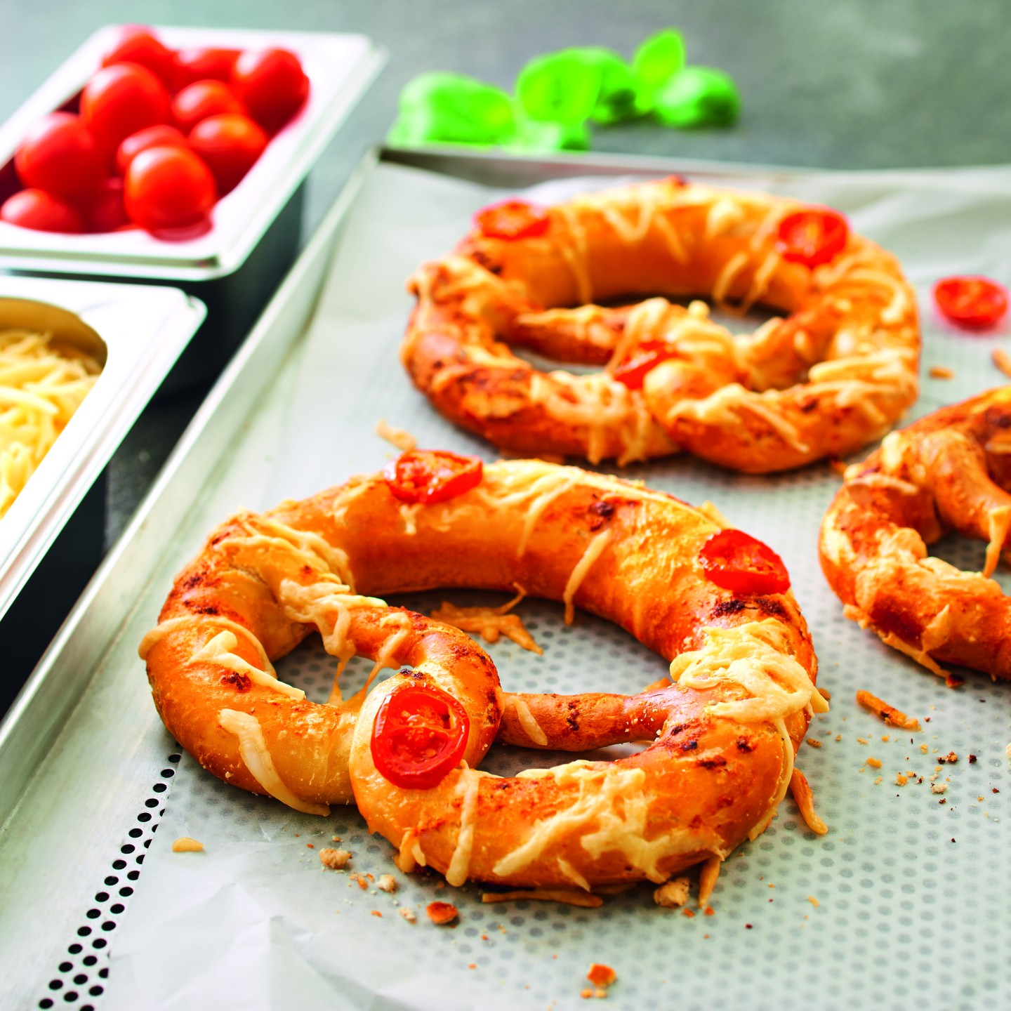 Two lye pretzels as pizza: tomato sauce, cheese and cherry tomatoes, baked.