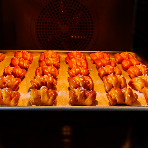 Ditsch Pretzel Bites lined up on a baking sheet in the oven.